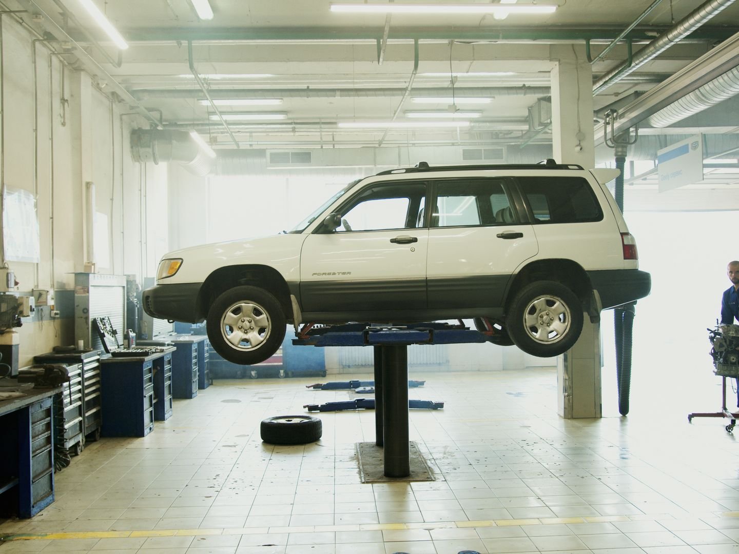 A car on a lift connected to a diagnostic laptop for ECU bench tuning
